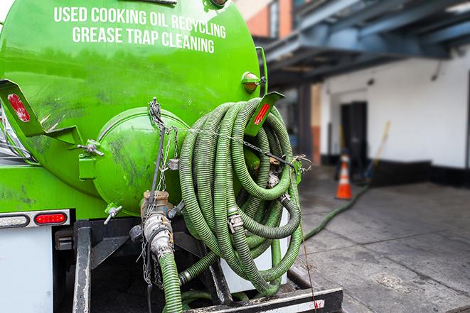 a grease trap being pumped by a sanitation technician in Niles